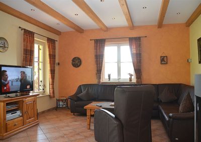 Das Wohnzimmer mit gemütlichem Ledersofa und Flachbildschirm.