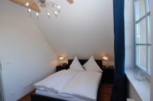 Schlafzimmer mit Doppelbett im Obergeschoss des Ferienhaus Victoria in Seedorf.