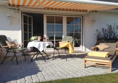 Die Terrasse mit exklusiven Gartenmöbeln von Garpa und einer Markise