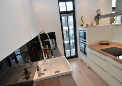 Die weiße Hochglanzküche mit Backofen und Mikrowelle in der Ferienwohnung Arwen in Sellin auf Rügen
