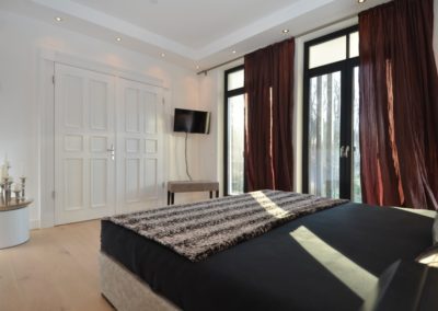 Das Schlafzimmer mit Doppelbett und Flatscreen der Ferienwohnung Arwen in Sellin auf Rügen