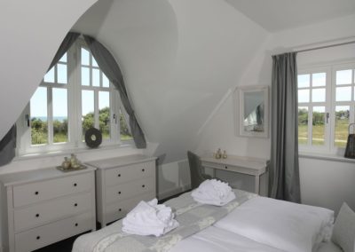 Schlafzimmer mit Doppelbett und Meerblick im Ferienhaus Ruden in Lobbe auf Rügen