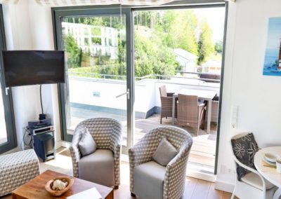 Der Wohnbereich mit Flatscreen, Sofa und Sessel des Penthouse Paulus in Sellin auf der Insel Rügen