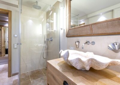 Das Duschbad mit Walk- In Dusche und einer riesengroßen Muschel als Waschschale im Ferienhaus Terpstich in Morsum