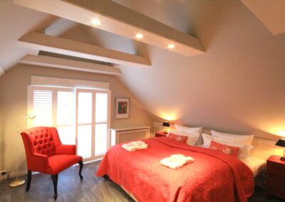 Schlafzimmer mit Dachbalken im Ferienhaus Rosenhus in Westerland auf Sylt