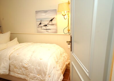 Das Schlafzimmer mit Einzelbett in der Ferienwohnung Lüvwai in Morsum auf der Insel Sylt.